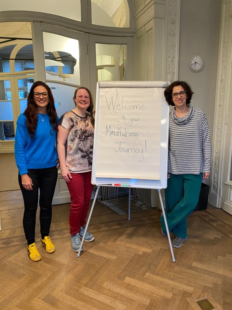 Teacher and assistants welcome  participants for MBSR course